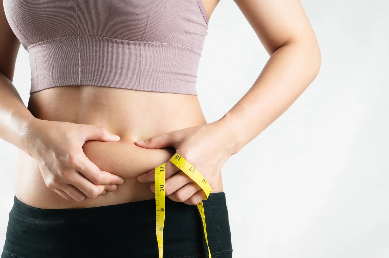 Concerned woman holding her belly, emphasizing weight loss 